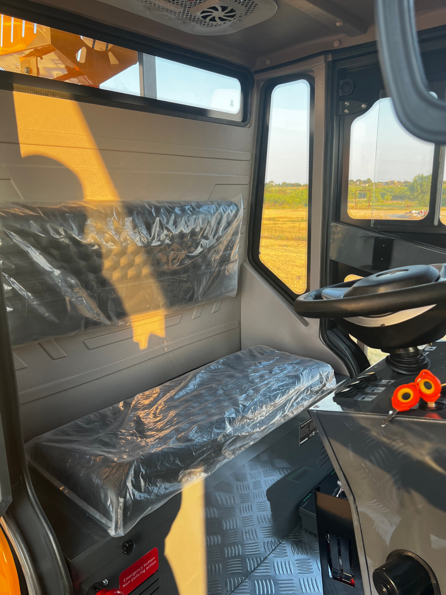 The TurfBoni™ roomy operator interior with seating, cup holders, and turf maintenance kit storage