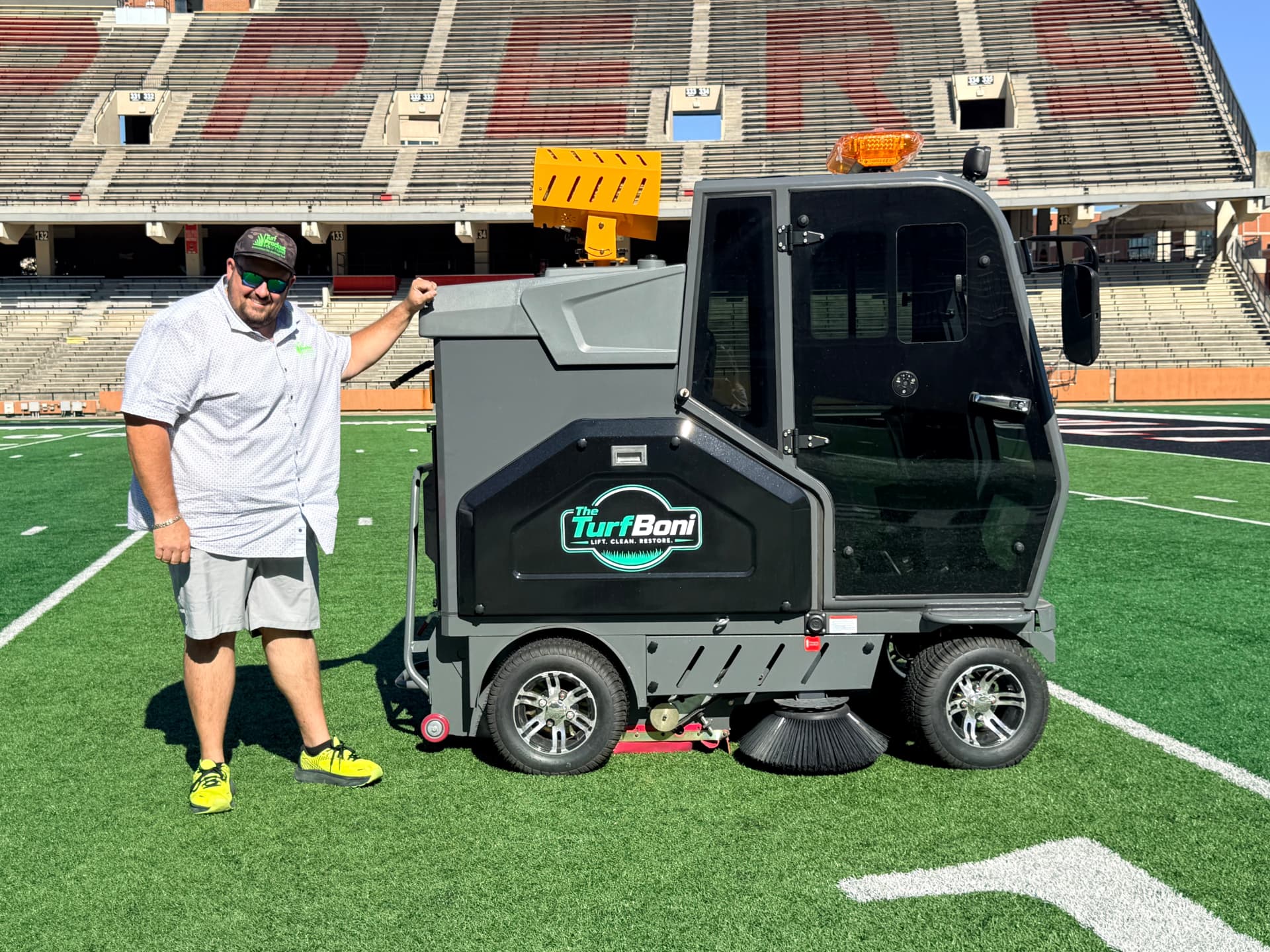 Nick Ogilvie, founder of Turf Product Solutions, standing beside The TurfBoni™ on a stadium turf field